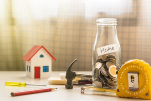 A photo of coin in glass bottle with capenter tool, Saving for new home concept
